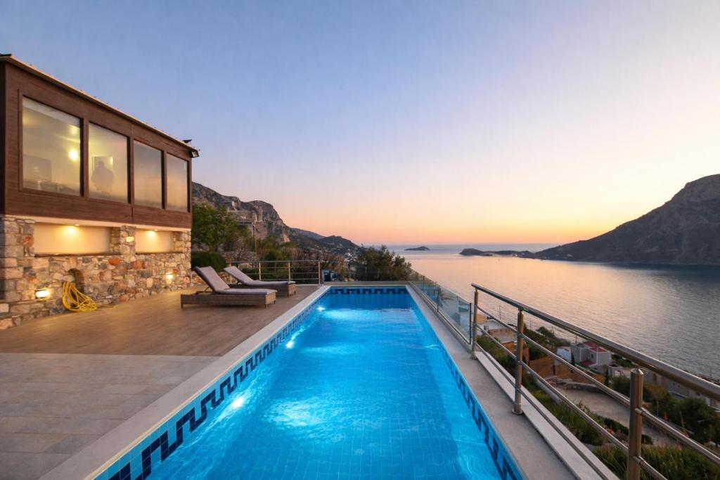 a house with a swimming pool next to the water at Villa Selas Kalymnos in Kalymnos