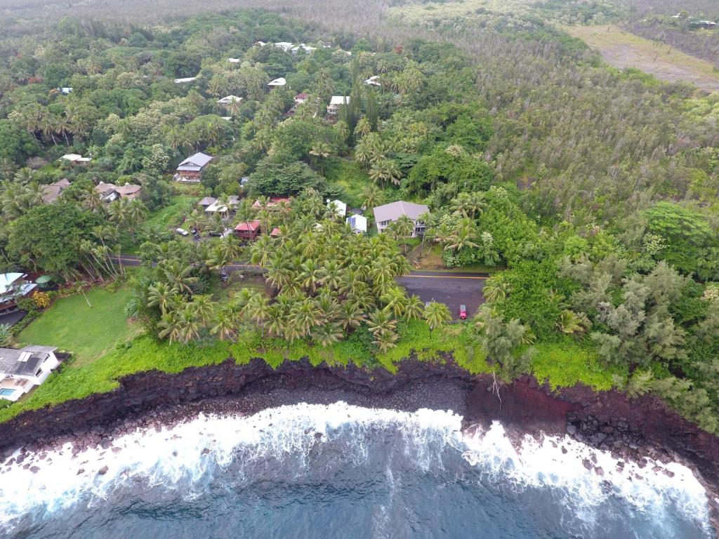 una vista aérea de una casa en una isla junto al océano en Whale House at Kehena Beach, en Pahoa