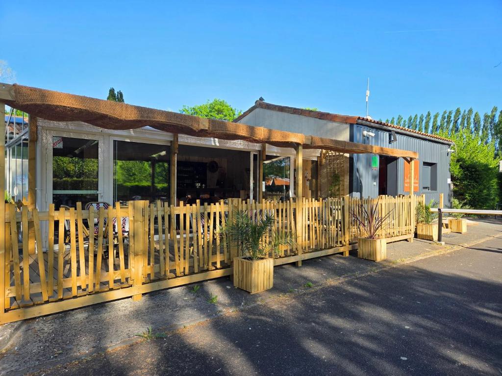 a wooden fence in front of a building at Camping Val de Boutonne in Saint-Jean-dʼAngély