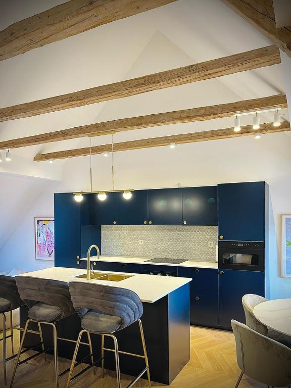 a kitchen with blue cabinets and a kitchen island with stools at Palais Wieserfeld in Steyr