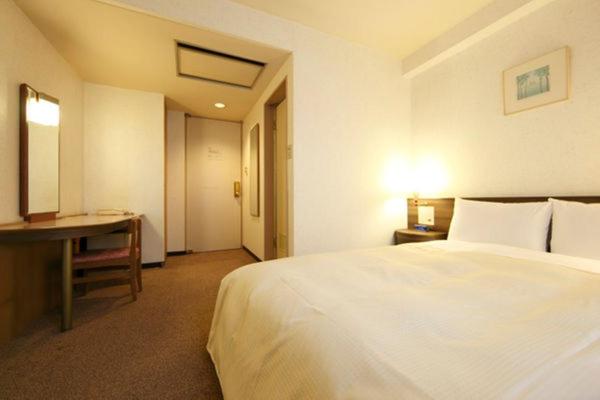 Postel nebo postele na pokoji v ubytování Urban Hotel Twins Chofu