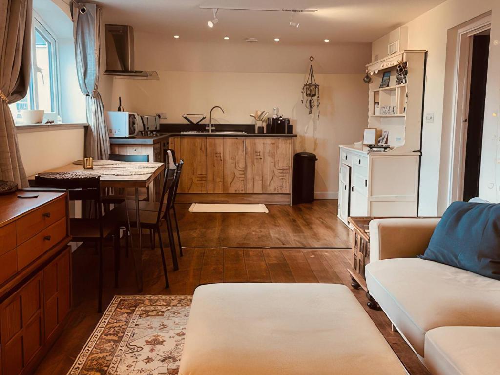 a kitchen and living room with a couch and a table at The Hideaway in Tintagel