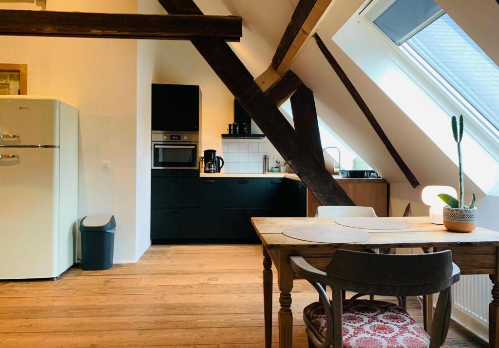 a kitchen with a table and a refrigerator at De Lotuspoort met Mihr's rustplek in de Abdij van Bornem in Bornem