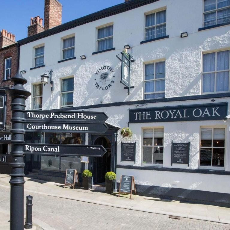 a building on a street with signs in front of it at The Royal Oak Ripon in Ripon