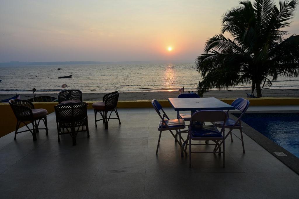 a table and chairs with a view of the ocean at Serenity by the Sea Goa in Silidao