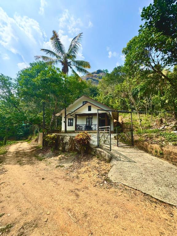 a small house in the middle of a dirt road at Wind Bells in Anaviratty