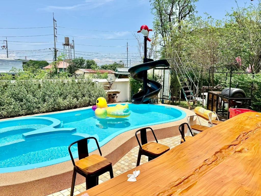 a pool with a slide and a table and chairs at Chiang Mai Private "Davin Pool Villa" CNX 2km to Central Festival in Chiang Mai