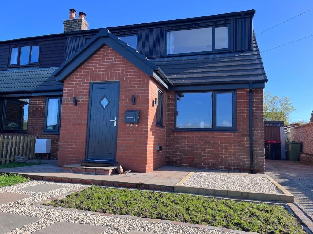 a house with a black roof and a blue door at Newly renovated countryside retreat in Scorton in Scorton