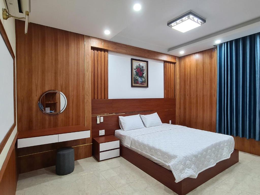 a bedroom with a bed with wooden walls and a mirror at Viet Trung Hotel in Nhơn Trạch