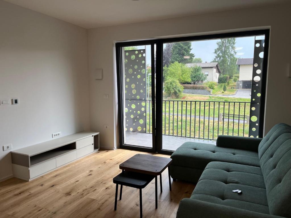 a living room with a couch and a large window at TB7 Sg in Slovenj Gradec