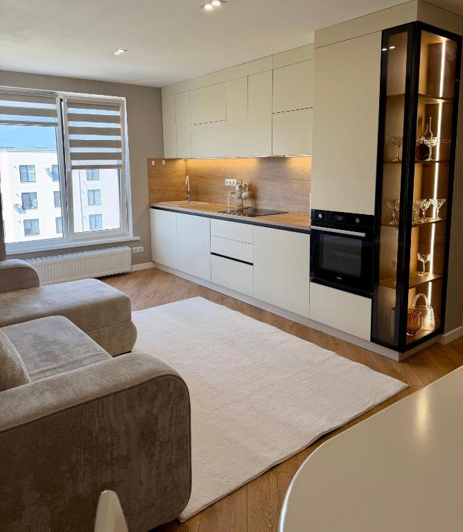 a kitchen with white cabinets and a black appliance at Inamstro Home in Orhei