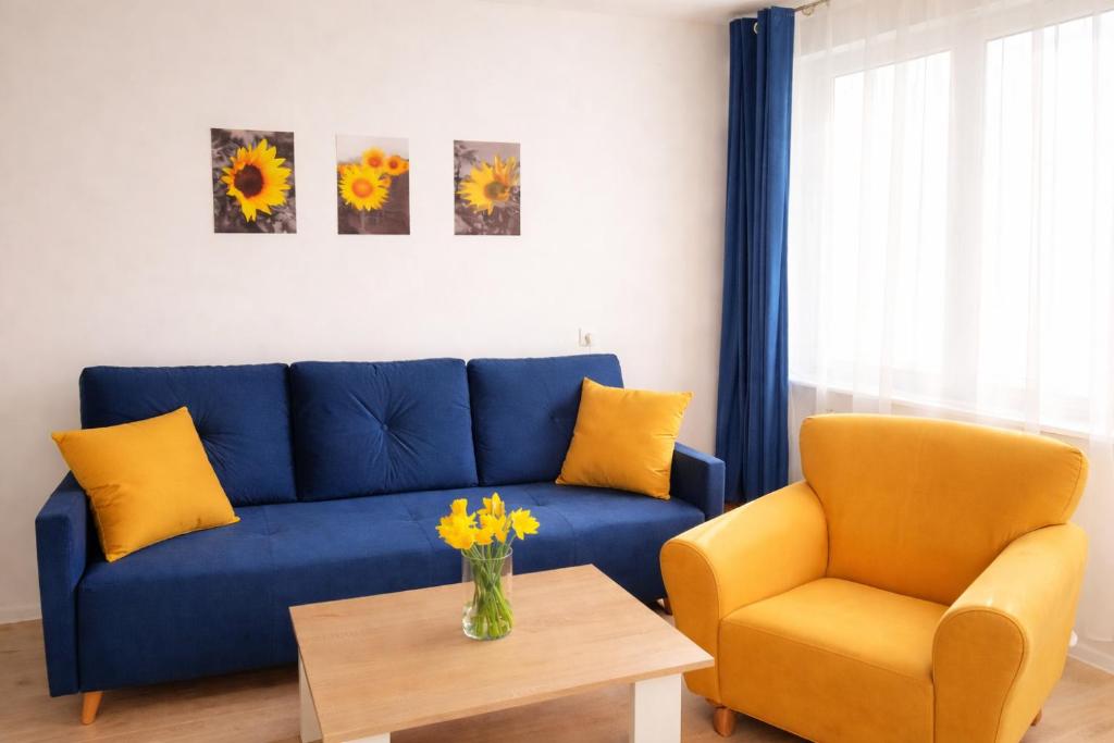 a blue couch and a chair in a living room at Apartament Bałtycka Sardynka in Ustka