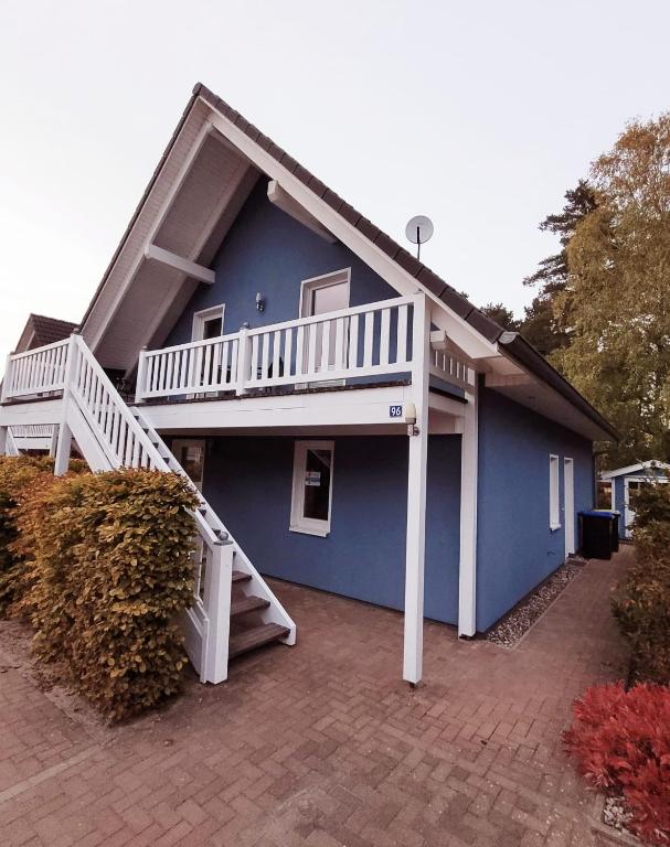 a blue house with a white deck and stairs at Haus Seeglück in Röbel
