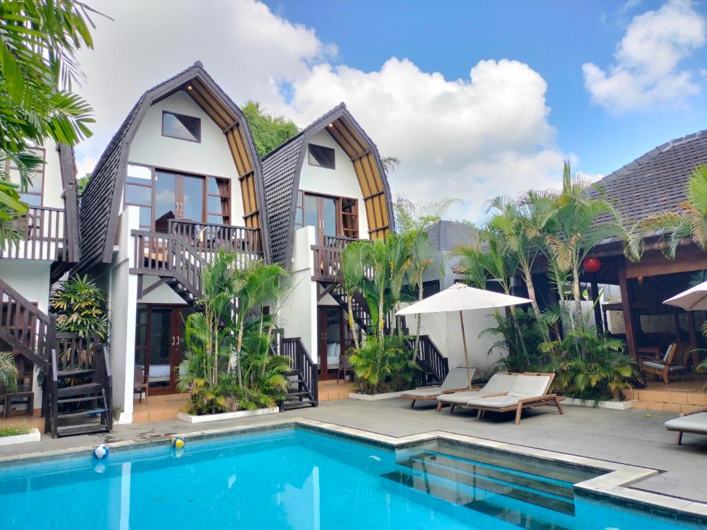 a villa with a swimming pool and a resort at Mojo Resort Canggu in Canggu