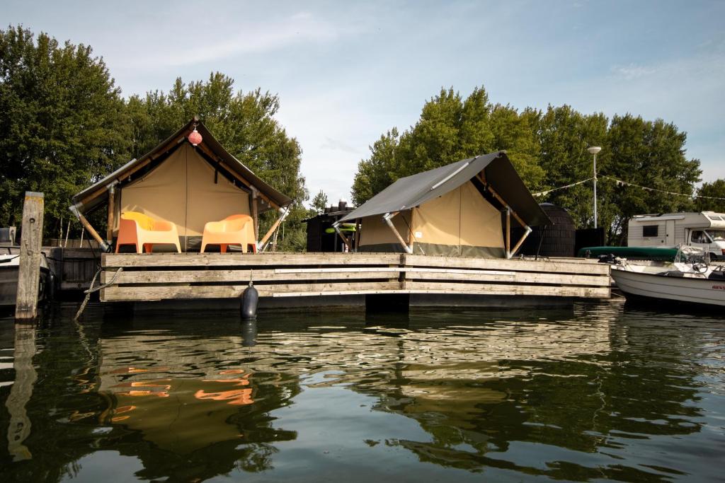 a couple of tents on a dock on a body of water at Safaritent 1 in Biddinghuizen