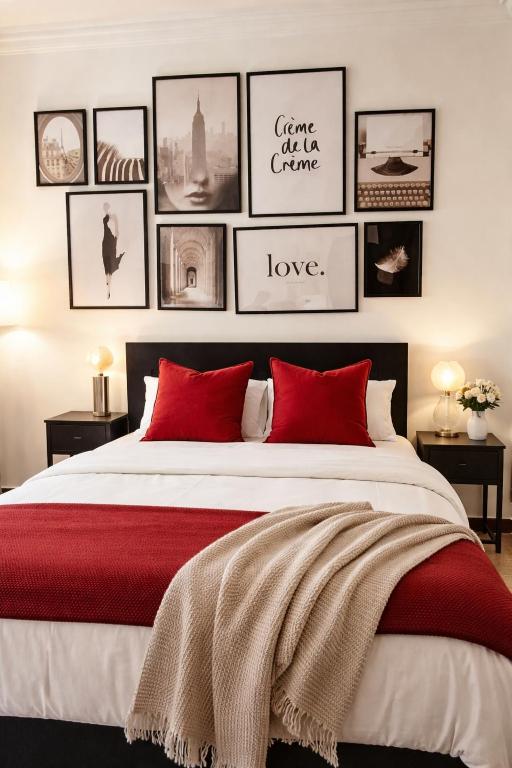 a bedroom with a large bed with red pillows and framed pictures at Euro Edens Brussels - Family Home & Free Gym Access in Brussels