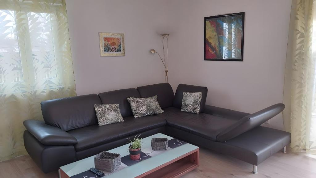 a black leather couch in a living room with a table at Herrmanns-Ferienhaus Wohnung 1 in Schlüsselfeld