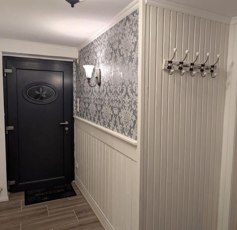 a hallway with a black door and a wall at Entspannen auf der Old Charmi Ranch in Kutenholz