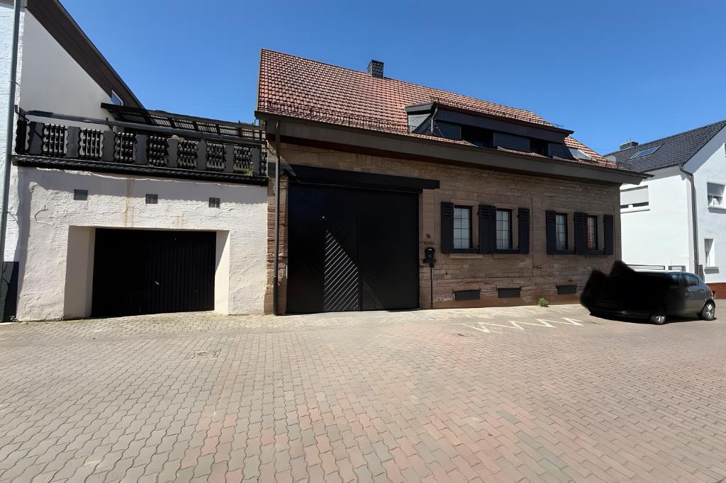 a car parked in front of a building with a garage at Viel Platz und Komfort in Orbis