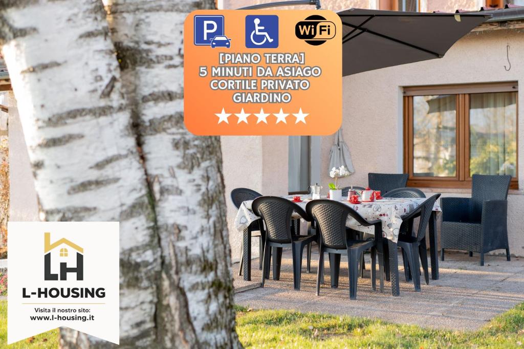 a table and chairs sitting in front of a building at Lhousing -Giardino con BBQ e Garage in Roana