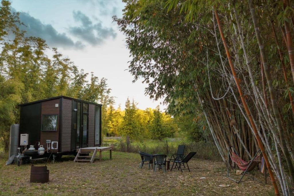 a cabin in the woods with a table and chairs at Bamboo Grove by Tiny Away in Bauple