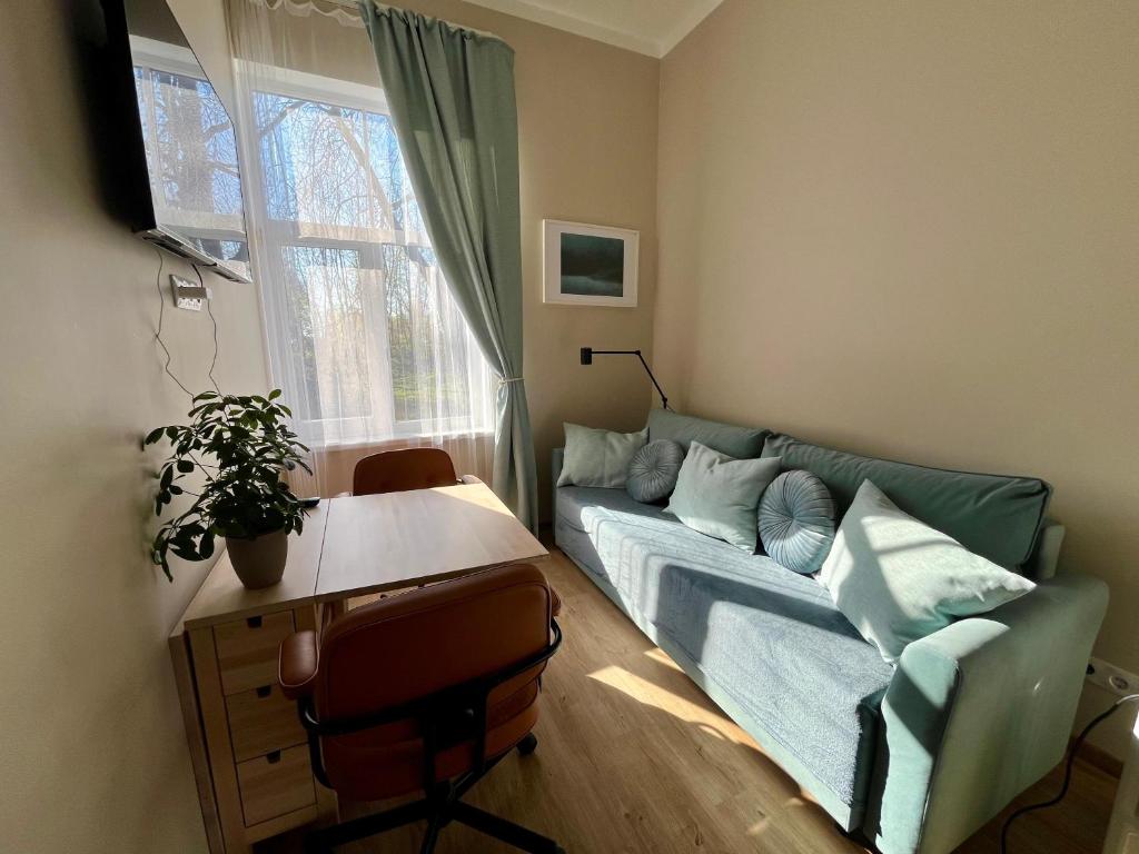 a living room with a couch and a window at RUMIDO Station in Valmiera