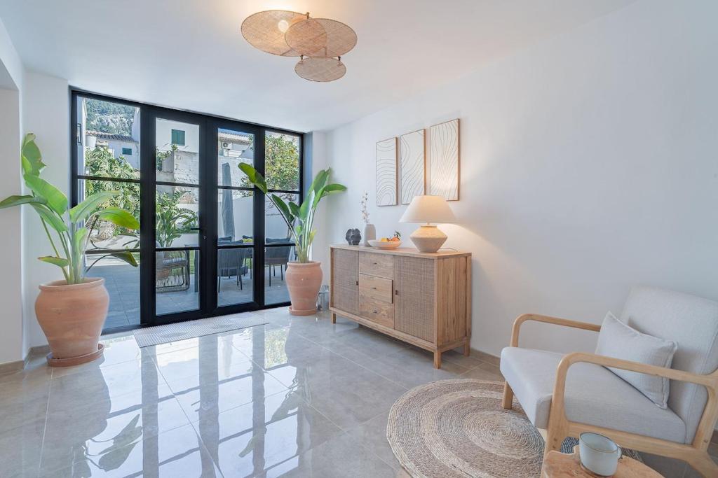 a living room with a couch and a chair and windows at Stadthaus mit Garten und Dachterrasse -Casa Villanova in Pollença