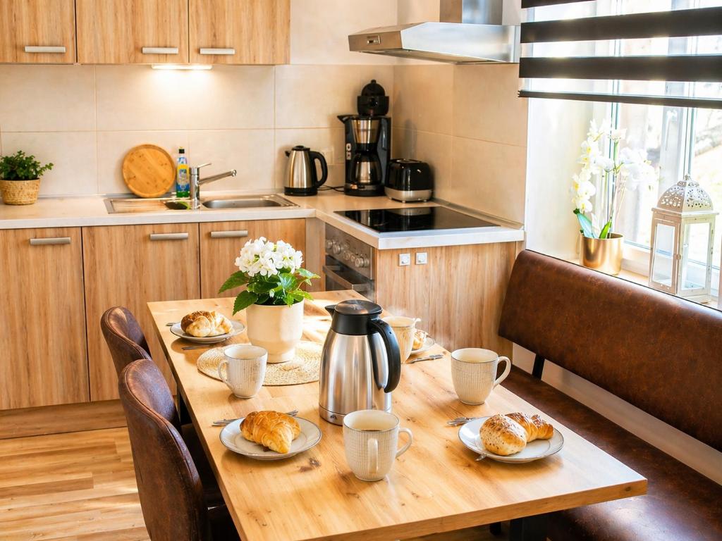 a kitchen with a wooden table with food on it at Komfortable Ferienwohnung 2x Schlafzimmer, Sauna zubuchbar, Parkplatz & Top Lage in Bad Muskau in Bad Muskau