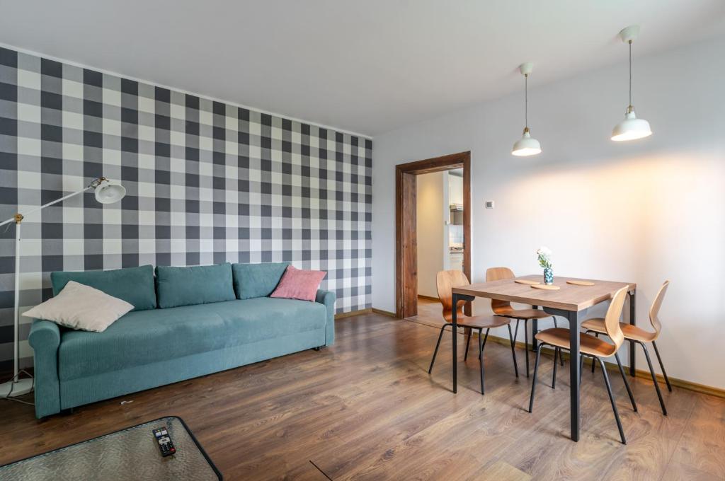 a living room with a blue couch and a table at Mastalerza Spacious Apartment by BookingHost in Gliwice