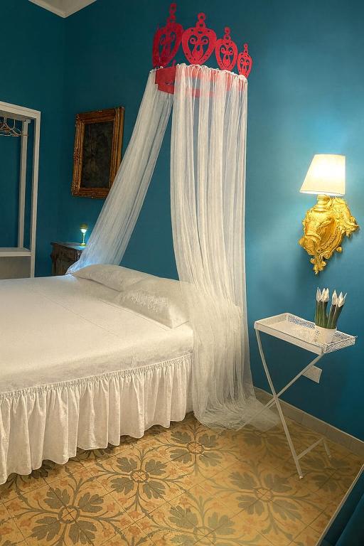 a bedroom with a bed with a red canopy at Vicolo Re suite in centro con stile in Porto Empedocle