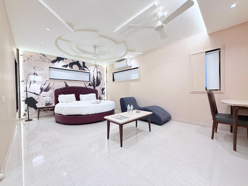a bedroom with a bed and a table and chairs at Hotel Nova Vista in Rajkot