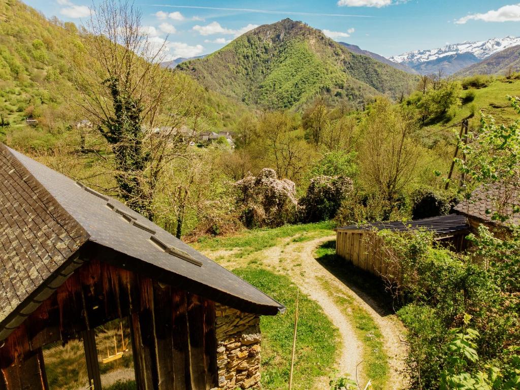 a dirt road next to a house with mountains in the background at La montana in Seix