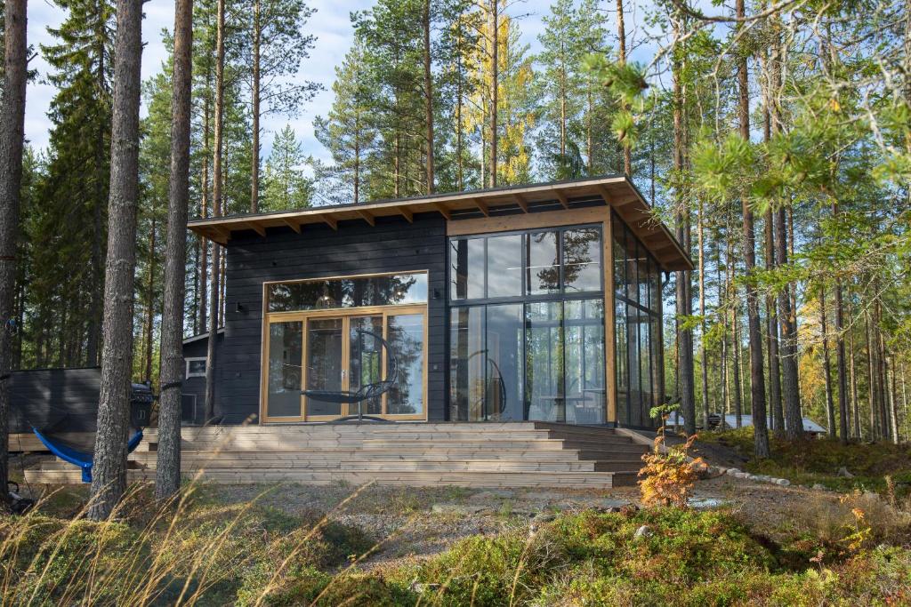 a tiny house in the woods with glass walls at Rantarovio in Alvajärvi