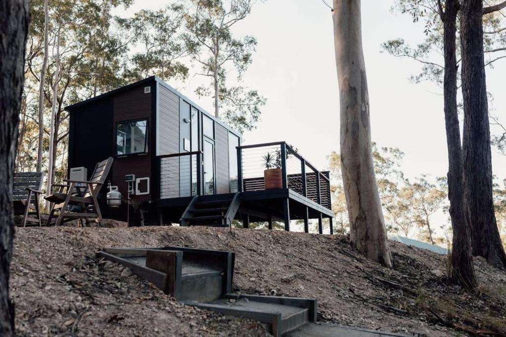a tiny house on a hill in the woods at Tiny Tamborine 1 by Tiny Away in Wongawallan