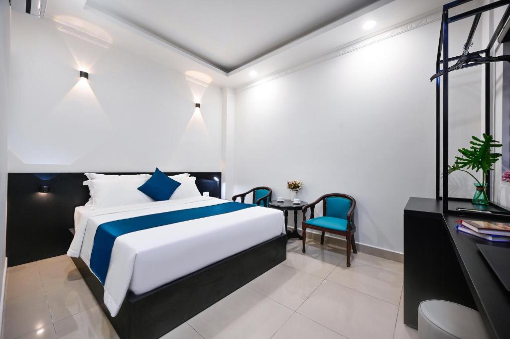 a hotel room with a bed and a table and chairs at Trung Mai Sân Bay T3 in Ho Chi Minh City