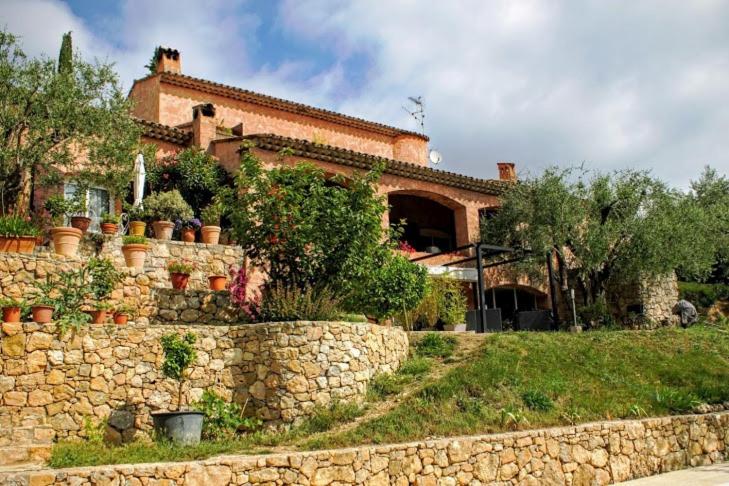 a stone wall in front of a house at Bastide Rose de Mai in Le Rouret