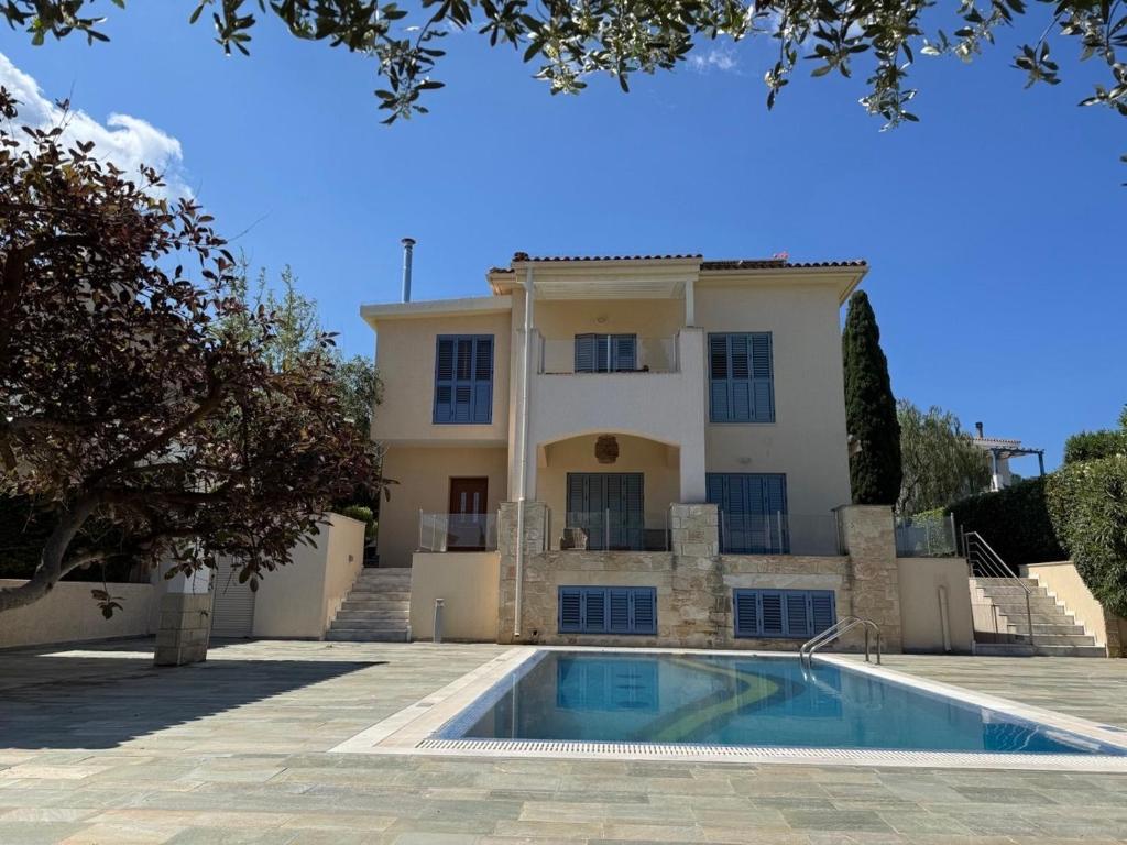 a house with a swimming pool in front of it at Beach villa Aurelia in Neo Chorio