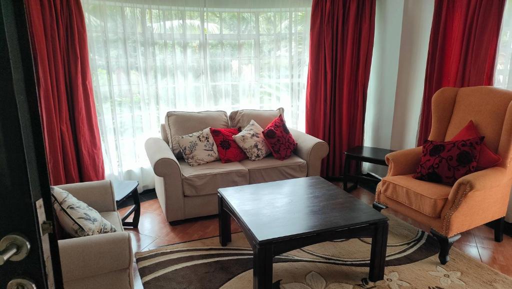 a living room with two chairs and a couch at rossylyn lonetree two bed bedroom in Nairobi