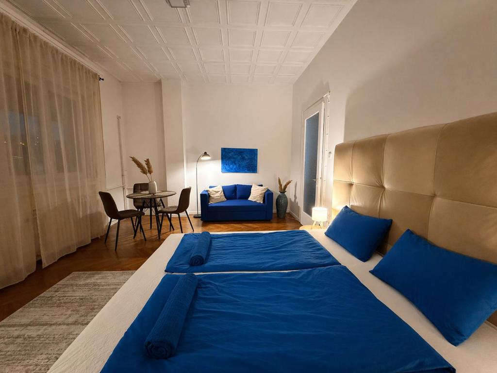 a bedroom with a large bed with blue pillows at Buda Blue in Budapest