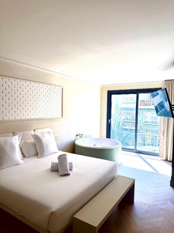 a bedroom with a large bed and a bath tub at AT Boutique Alma in Alicante