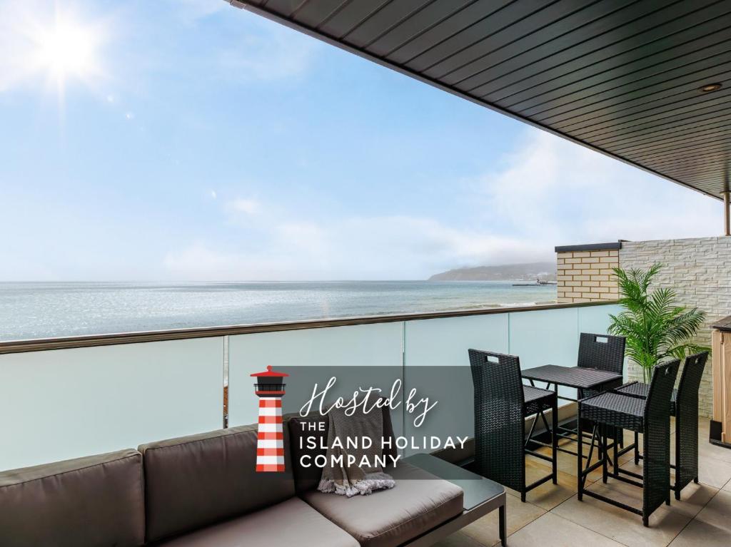 a view of the ocean from the balcony of a house at Colonels Rest - Luxury Beachside Townhouse with Sea Views in Sandown, Sleeps 10 in Sandown