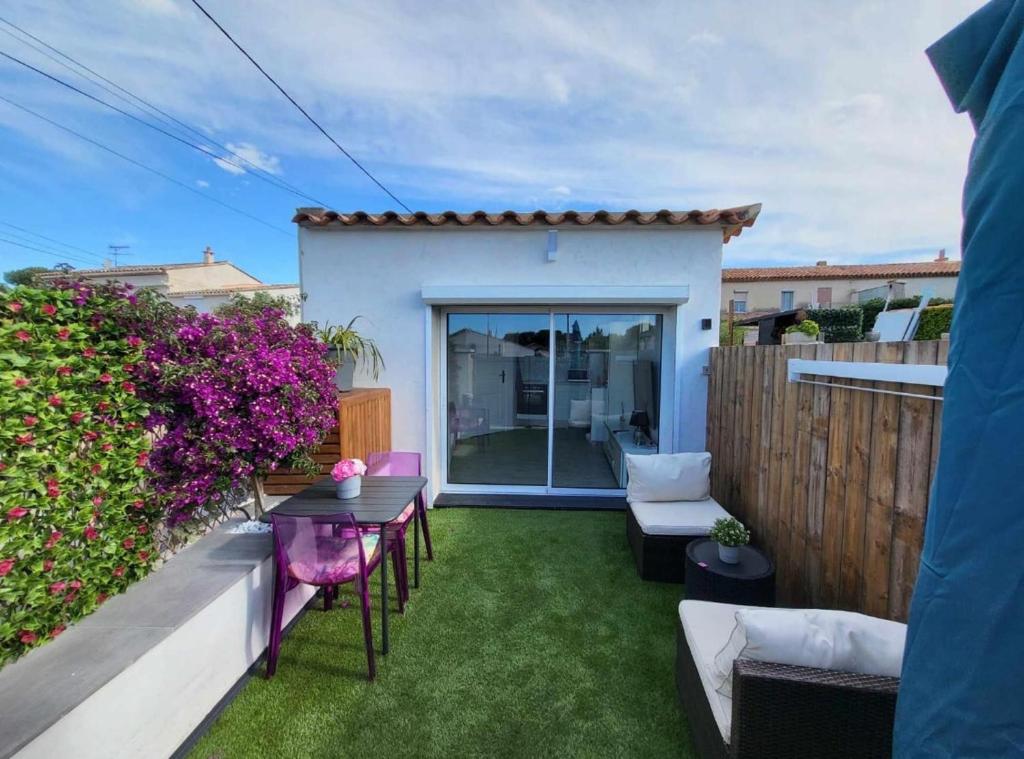 a small backyard with a table and chairs on the grass at Studio Villa Loostic in Martigues
