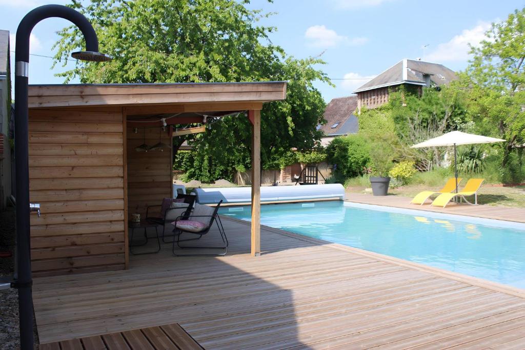 a deck with a pavilion next to a swimming pool at Gîtes La Grenouillère in Veuzain-sur-Loire