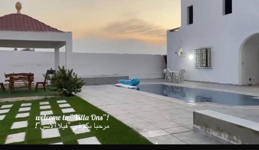 a villa with a swimming pool next to the ocean at Ali yessine in Al Maqārisah