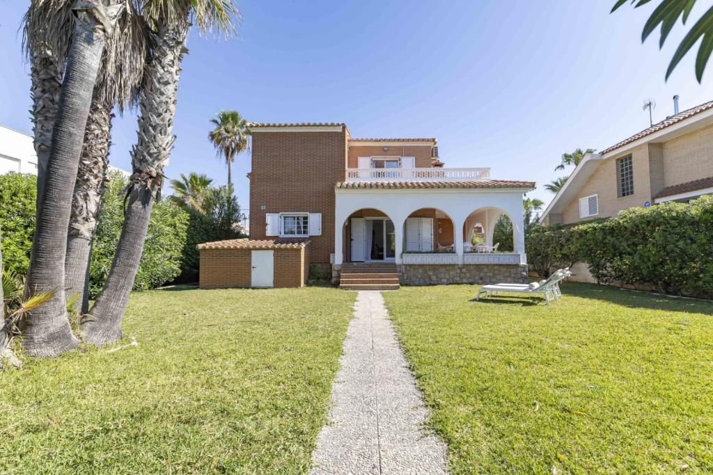 a house with palm trees in the yard at Beachfront Rental Home & Sea Views by Invalencia in Sagunto