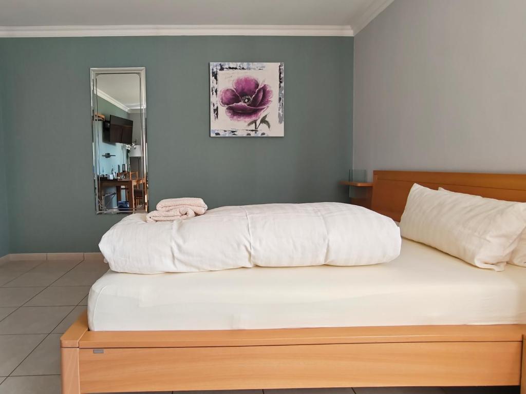a bedroom with a large white bed with a mirror at Bed and Breakfast am Höhenweg in Warstein
