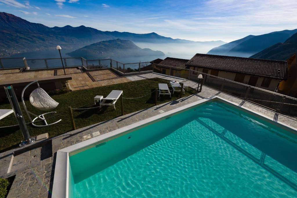 a swimming pool with a view of mountains at EnjoyIseoLake - Lake View Paradise in Parzanica