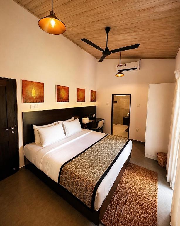 a bedroom with a large bed and a ceiling fan at Samadhi Lagoon Villa in Ratgama Hegoda