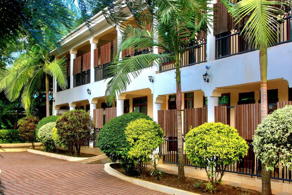 a building with palm trees in front of it at Moshono WiDa Lodge in Arusha