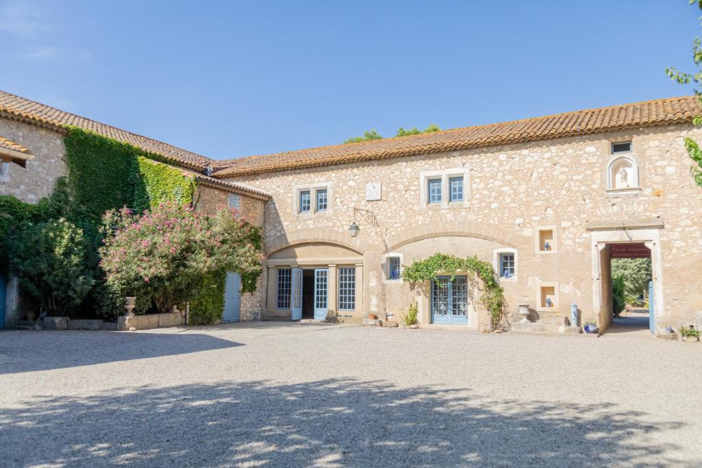 a large stone building with a driveway in front at Château Pech-Céleyran in Salles-dʼAude
